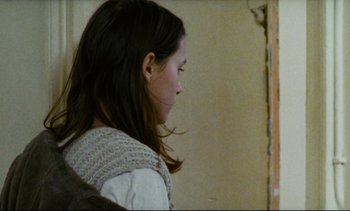 Movie still from “Cold Water” (1994), directed by Olivier Assayas – A young girl with long brown hair wearing a sweater; Close Up shot, Over the shoulder angle