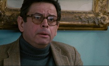 Movie still from “Cold Water” (1994), directed by Olivier Assayas – A person wearing glasses and a jacket; Close Up shot, Over the shoulder angle