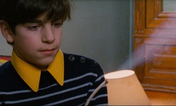 Movie still from “Cold Water” (1994), directed by Olivier Assayas – A young boy wearing a striped shirt and a yellow tie; Close Up shot, Low angle
