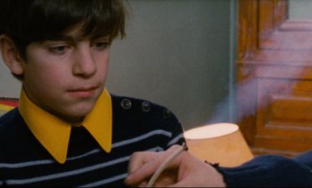 Movie still from “Cold Water” (1994), directed by Olivier Assayas – A young boy wearing a striped shirt and a yellow tie; Close Up shot, Low angle