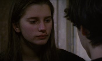 Movie still from “Cold Water” (1994), directed by Olivier Assayas – A young woman looking at the camera while a man looks at her face; Close Up shot, Over the shoulder angle