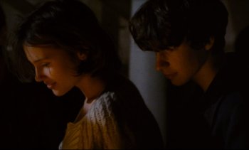 Movie still from “Cold Water” (1994), directed by Olivier Assayas – Two young people standing next to each other in a dark room; Close Up shot, Over the shoulder angle