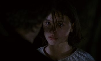 Movie still from “Cold Water” (1994), directed by Olivier Assayas – A young woman is looking into the camera; Close Up shot, Over the shoulder angle