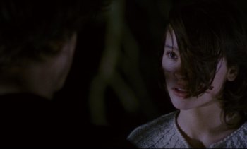 Movie still from “Cold Water” (1994), directed by Olivier Assayas – A young woman looking at the camera while a man looks at her; Close Up shot, Over the shoulder angle