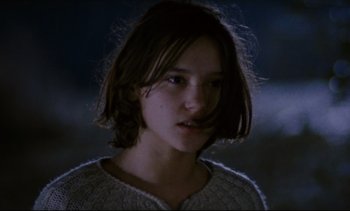 Movie still from “Cold Water” (1994), directed by Olivier Assayas – A young woman with long dark hair wearing a sweater; Close Up shot, Low angle