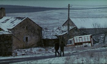 Movie still from “Cold Water” (1994), directed by Olivier Assayas – Two people walking on a road near a house; Extreme Wide shot, High angle