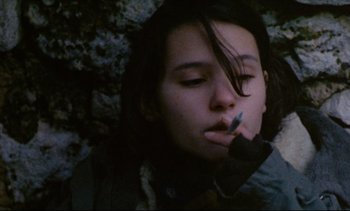 Movie still from “Cold Water” (1994), directed by Olivier Assayas – A young woman is smoking a cigarette in the dark; Close Up shot, Low angle