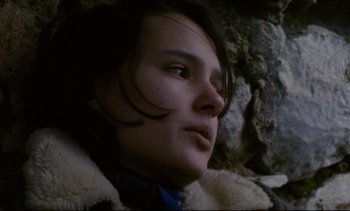 Movie still from “Cold Water” (1994), directed by Olivier Assayas – A person wearing a jacket near a rock wall; Close Up shot, Low angle