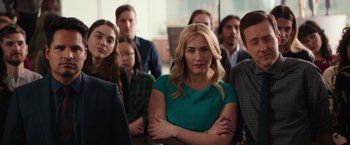Movie still from “Collateral Beauty” (2016), directed by David Frankel – A group of people standing in a room with their arms crossed; Medium shot, Over the shoulder angle