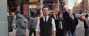 Movie still from “Collateral Beauty” (2016), directed by David Frankel – A man in a vest and tie standing on the street; Medium shot, Over the shoulder angle