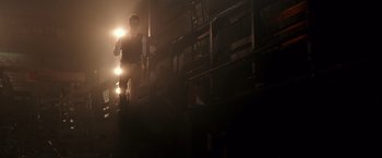 Movie still from “Collateral Beauty” (2016), directed by David Frankel – A man standing in a dark room holding a flashlight; Wide shot, Low angle