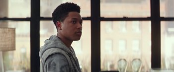 Movie still from “Collateral Beauty” (2016), directed by David Frankel – A young man is standing in front of a window; Close Up shot, Over the shoulder angle