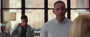 Movie still from “Collateral Beauty” (2016), directed by David Frankel – A man standing next to another man in front of a window; Close Up shot, Over the shoulder angle