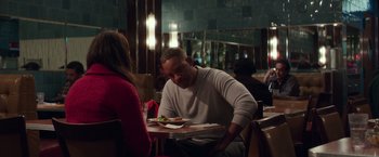 Movie still from “Collateral Beauty” (2016), directed by David Frankel – A man sitting at a table with a plate in front of a woman; Medium shot, Over the shoulder angle