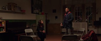 Movie still from “Collateral Beauty” (2016), directed by David Frankel – A man and a woman are in a room with folding chairs; Wide shot, Over the shoulder angle