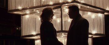 Movie still from “Collateral Beauty” (2016), directed by David Frankel – A man and a woman standing next to each other in front of lights; Medium shot, Over the shoulder angle