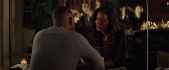 Movie still from “Collateral Beauty” (2016), directed by David Frankel – A man and a woman are sitting at a table talking; Medium shot, Over the shoulder angle