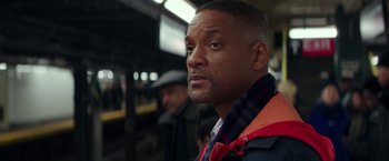 Movie still from “Collateral Beauty” (2016), directed by David Frankel – A person wearing a jacket on a train; Close Up shot, Over the shoulder angle
