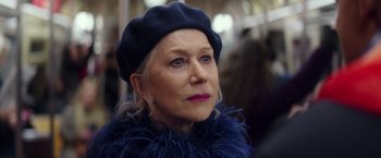 Movie still from “Collateral Beauty” (2016), directed by David Frankel – An older woman wearing a blue hat and a feather boa; Close Up shot, Over the shoulder angle