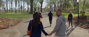 Movie still from “Collateral Beauty” (2016), directed by David Frankel – A man and a woman holding hands while walking down a path; Medium shot, Over the shoulder angle