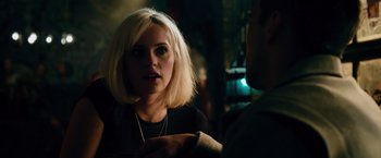 Movie still from “Collide” (2016), directed by Eran Creevy – A woman with blonde hair talking to a man in a dark room; Close Up shot, Over the shoulder angle