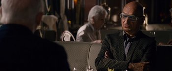 Movie still from “Collide” (2016), directed by Eran Creevy – A man sitting at a table in front of a woman; Medium shot, Over the shoulder angle