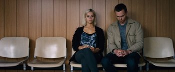 Movie still from “Collide” (2016), directed by Eran Creevy – A woman sitting next to a man on a chair; Medium shot, High angle