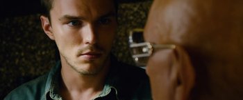Movie still from “Collide” (2016), directed by Eran Creevy – A person looking at a mirror; Close Up shot, Over the shoulder angle