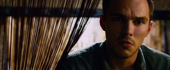 Movie still from “Collide” (2016), directed by Eran Creevy – A man's face with a bunch of hair hanging in the background; Close Up shot, Low angle