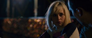 Movie still from “Collide” (2016), directed by Eran Creevy – A woman with blonde hair is looking at the camera; Close Up shot, Over the shoulder angle