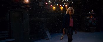 Movie still from “Collide” (2016), directed by Eran Creevy – A woman walking in the snow holding a bottle of wine; Wide shot, Low angle