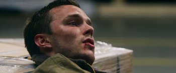 Movie still from “Collide” (2016), directed by Eran Creevy – A man's face while sitting on a couch; Close Up shot, Low angle
