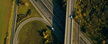 Movie still from “Collide” (2016), directed by Eran Creevy – An aerial view of a highway with cars driving on it; Extreme Wide shot, Overhead angle
