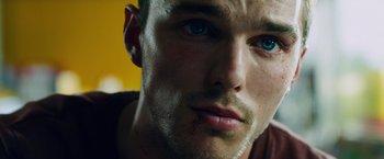 Movie still from “Collide” (2016), directed by Eran Creevy – A person with a bruise on his face; Extreme Close Up shot, Overhead angle