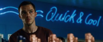 Movie still from “Collide” (2016), directed by Eran Creevy – A person sitting in front of a sign; Close Up shot, Over the shoulder angle