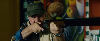 Movie still from “Collide” (2016), directed by Eran Creevy – A man holding a gun in his hands; Close Up shot, Low angle
