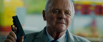 Movie still from “Collide” (2016), directed by Eran Creevy – An older man wearing a suit and tie looking to his left; Close Up shot, Low angle