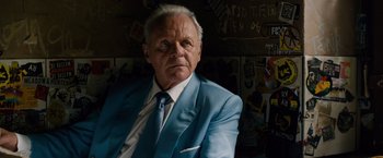 Movie still from “Collide” (2016), directed by Eran Creevy – An older man wearing a blue suit and tie; Close Up shot, Over the shoulder angle