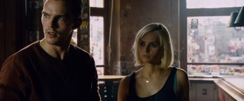 Movie still from “Collide” (2016), directed by Eran Creevy – A woman with short blonde hair standing next to a man; Close Up shot, Over the shoulder angle