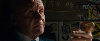 Movie still from “Collide” (2016), directed by Eran Creevy – An older man wearing a blue shirt and a tie; Close Up shot, Low angle