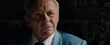 Movie still from “Collide” (2016), directed by Eran Creevy – An older man wearing a blue suit and tie; Close Up shot, Low angle