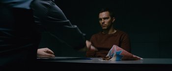 Movie still from “Collide” (2016), directed by Eran Creevy – A man sitting in front of a table with papers; Close Up shot, Over the shoulder angle