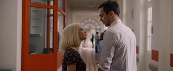 Movie still from “Collide” (2016), directed by Eran Creevy – A man and a woman standing next to each other in a hallway; Medium shot, Over the shoulder angle