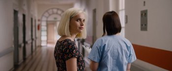 Movie still from “Collide” (2016), directed by Eran Creevy – A woman standing next to another woman in a hallway; Close Up shot, Over the shoulder angle