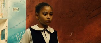 Movie still from “Colombiana” (2011), directed by Olivier Megaton – A young girl wearing a black and white shirt; Close Up shot, Low angle