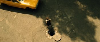Movie still from “Colombiana” (2011), directed by Olivier Megaton – An aerial view of a cat standing next to a fire hydrant; Extreme Wide shot, Overhead angle