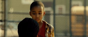 Movie still from “Colombiana” (2011), directed by Olivier Megaton – A young boy is looking down at his head; Close Up shot, Over the shoulder angle