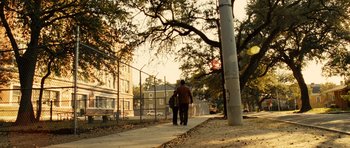 Movie still from “Colombiana” (2011), directed by Olivier Megaton – A man walking down a sidewalk with a umbrella; Extreme Wide shot, Low angle