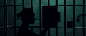 Movie still from “Colombiana” (2011), directed by Olivier Megaton – A person is looking through a jail cell window; Close Up shot, Low angle