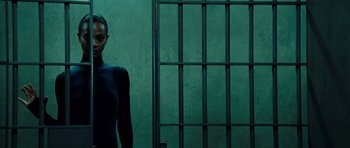 Movie still from “Colombiana” (2011), directed by Olivier Megaton – A man standing in front of a metal gate; Medium shot, Low angle